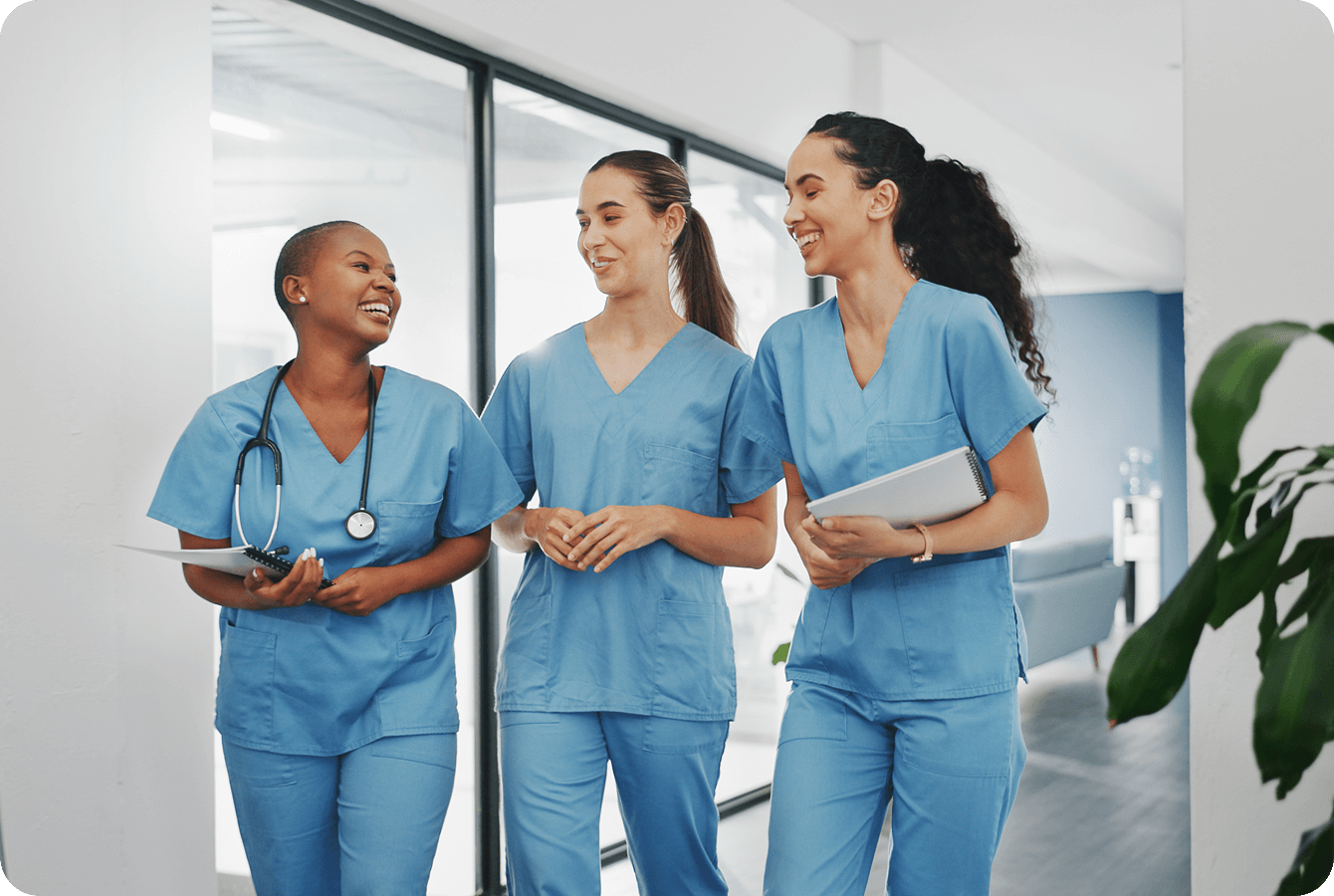 Three nurses walking and smiling together.